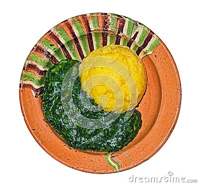 Stewed nettles with polenta in a rustic traditional clay bowl Stock Photo