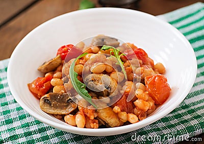 Stewed white beans with mushrooms and tomatoes with spicy sauce Stock Photo