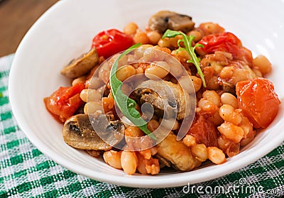 Stewed white beans with mushrooms and tomatoes with spicy sauce Stock Photo