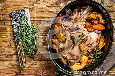 Stewed whole lamb shoulder in a baking dish. Wooden background. Top view Stock Photo