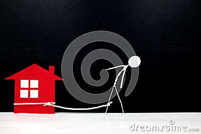Stick man chained on a red house. Housing loan and mortgage burden concept. Stock Photo
