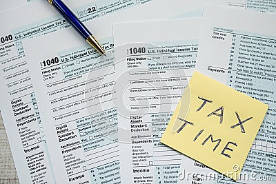 sticker with text TAX TIME with 2022 blank 1040 tax form Editorial Stock Photo