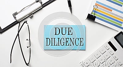 Stickers with chart,calculator and paper with text DUE DILIGENCE on white background Stock Photo