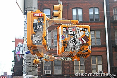 Stickers and graffiti on yellow street lights Editorial Stock Photo