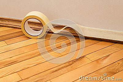 Sticking masking tape to the baseboard Stock Photo