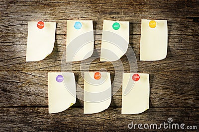 Sticky note with pin overWeekly Sticky Note with colourful pin over wooden background Stock Photo