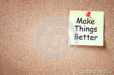 Sticky note pinned to cork board with the phrase make things better written on it room for text Stock Photo