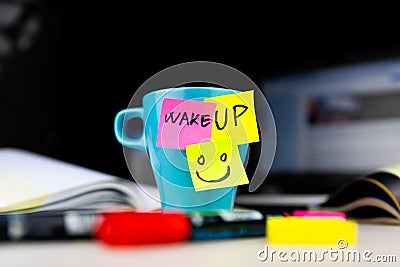 Sticky notes on a coffe cup at office desk. Wake up and smile. Begin your day with Positive thoughts Stock Photo