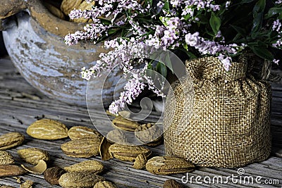 Still life. Almond nuts in a clay pot on a wooden table closeup Stock Photo