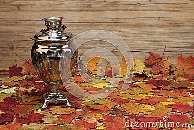 Still life art photography with an antique samovar with autumn leaves on a wooden background Stock Photo
