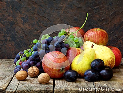 Still life of autumn fruits: grapes, apples, pears, plums, nuts Stock Photo