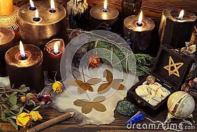 Still life with black candles, four-leaf clover, runes, crystals and magic objects on witch table Stock Photo