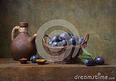 Still life with black plums in a basket Stock Photo