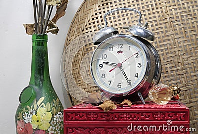 Still life with broken alarm clock, old glass vase with dead rose, classic perfume, vintage box. Stock Photo