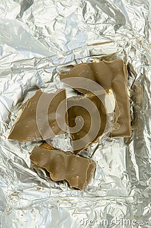 Still life with a close-up view of a broken table of milk chocolate with almonds Stock Photo