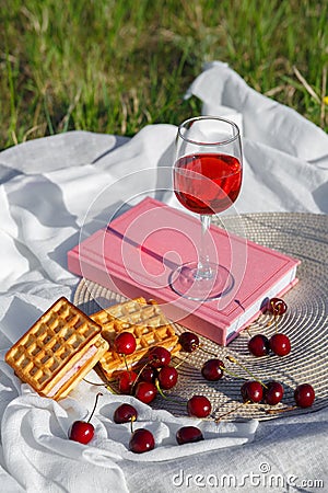 Still life and food photo. Cherry and waffle berries lie on a wicker round napkin and crumpled fabric Stock Photo