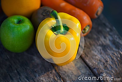 Still life fruit with yellow bell pepper green apple carrot orange and kiwi on rustic wood Stock Photo