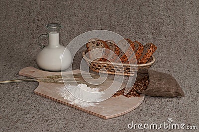 Still life with grains of wheat, spikes, bread, flour and milk. Stock Photo