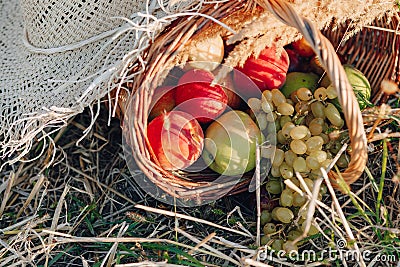 Still life with hat, bouquet, fruit in a basket in a field on hay. sunny summer weather Stock Photo