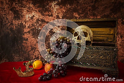 Still life with a human skull with fake apples and grapes Stock Photo