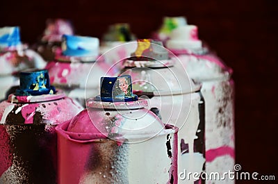 Still life with a large number of used colorful spray cans of aerosol paint lying on the treated wooden surface in the artist`s Stock Photo