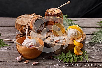 Still life with lemon and honey, on a wooden background in a rustic style. The concept of treating colds. Ethnoscience Stock Photo