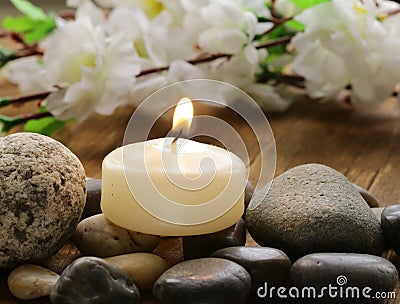 Still life a lit candle and stones Stock Photo