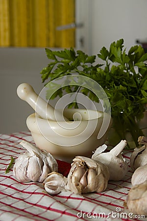 Still life of a mortar with some purple garlic and a bouquet of parsley Stock Photo