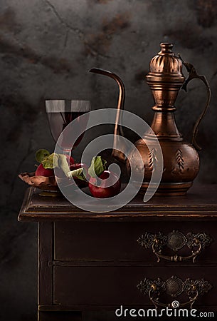 Still life with red wine, antique copper jug and apples Stock Photo