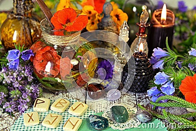 Still life with reiki crystals, runes, black candles and witch herbal potions on table Stock Photo