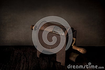 Still life with rustic rusty coffee roaster on vintage grunge background. Side view, cross light Stock Photo