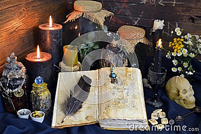 Still life with spell book, magic jars with plants and potion on witch table Stock Photo