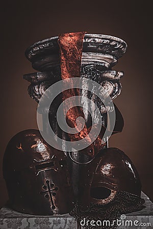 Still life at studio withs belt, ancient pedestal and helmets. Stock Photo