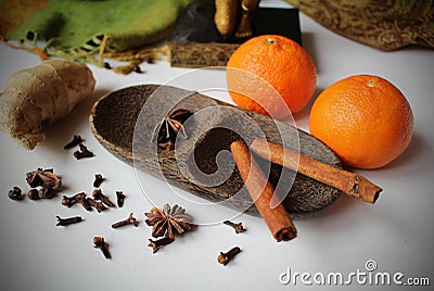 Still life - two tangerines and spice - ginger, cloves, star aniseed, black pepper and cinnamon arranged on a wooden bowl Stock Photo