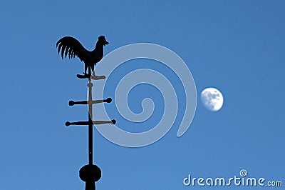 Still life of weathercock and moon in blue sky Stock Photo