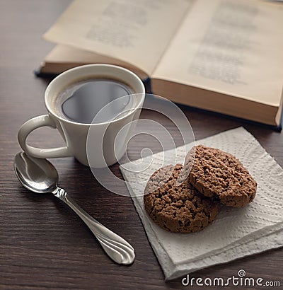 Still life. White cup with coffee and cookies in front of an open book with poetry Stock Photo