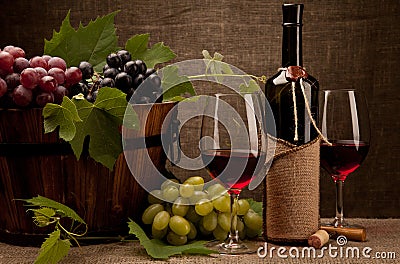 Still life with wine bottles, glasses and grapes Stock Photo