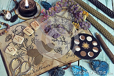 Still life with witch diary book and healing herbs drawings, clover, crystals and candles Stock Photo