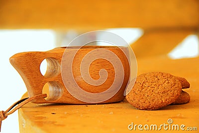 Still life of a wooden mug and cookies on a wooden table Stock Photo