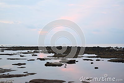 Still Sea Water during Low Tide at Littoral Zone - Pinkish Blue Clear Morning Sky with Reflection in Water - Natural Background Stock Photo