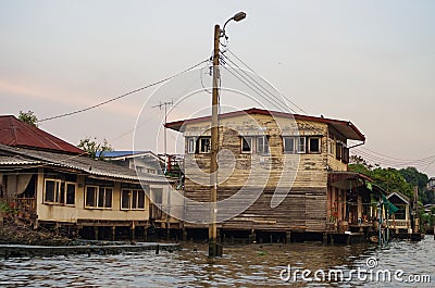 Stilt houses at a klong in Bangkok. Klongs are the canals, that branch off from Chao Phraya river, the big river of Bangkok. The Stock Photo