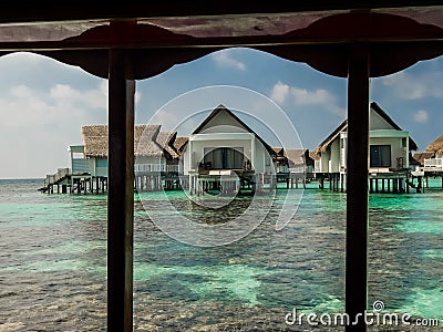 Stilt huts over a tropical lagoon at a resort Stock Photo