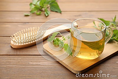 Stinging nettle infusion, leaves and brush on table. Natural hair care Stock Photo