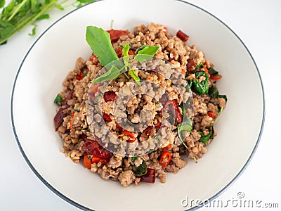 Stir fried basil with minced on a white plate,Thai food hot and spicy flavor. The ingredients are basil, garlic. Minced pork and C Stock Photo