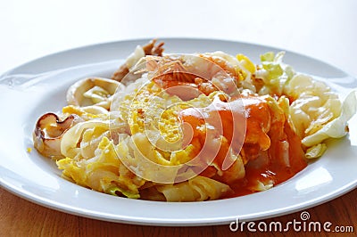 Stir fried large noodle seafood and cabbage dressing chili on plate Stock Photo