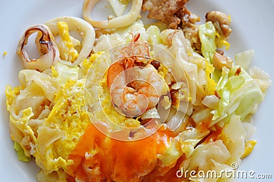 Stir fried large noodle seafood and egg dressing chili on plate Stock Photo