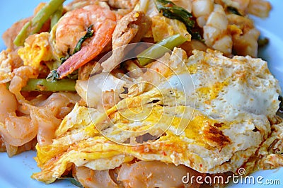 Stir fried large noodle seafood and egg with sukiyaki sauce on dish Stock Photo