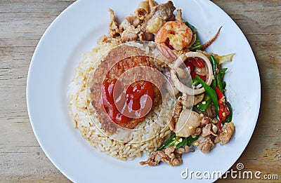 Stir fried mixed seafood with sweet long chili and deep fried pork on rice Stock Photo
