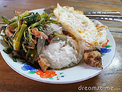Stir fried pork curry and vegetable with fied egg, spicy Thai food Stock Photo