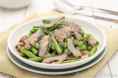 Stir-fried pork with yardlong beans served on the white plate Stock Photo